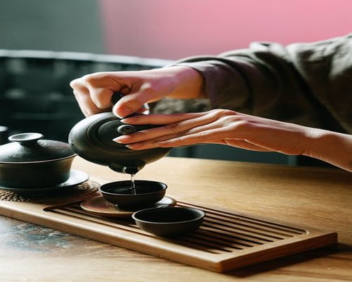 Person pouring tea in a calm bright environment